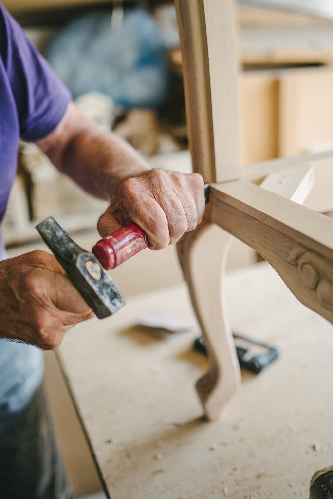 Craftsman shaping a wooden furniture leg